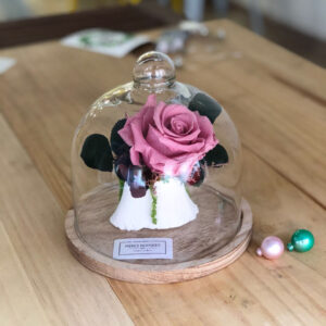Urna de cristal decorada con rosa y flor preservada