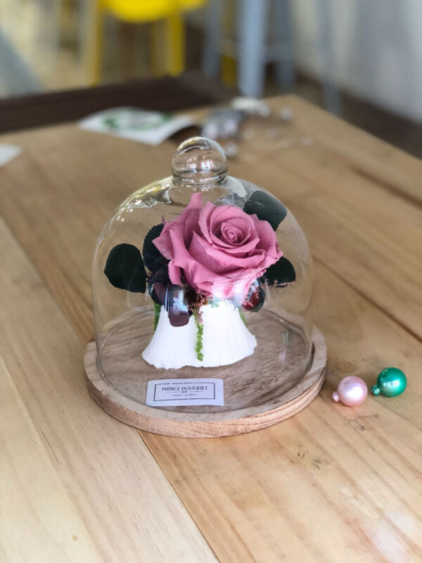 Urna de cristal decorada con rosa y flor preservada